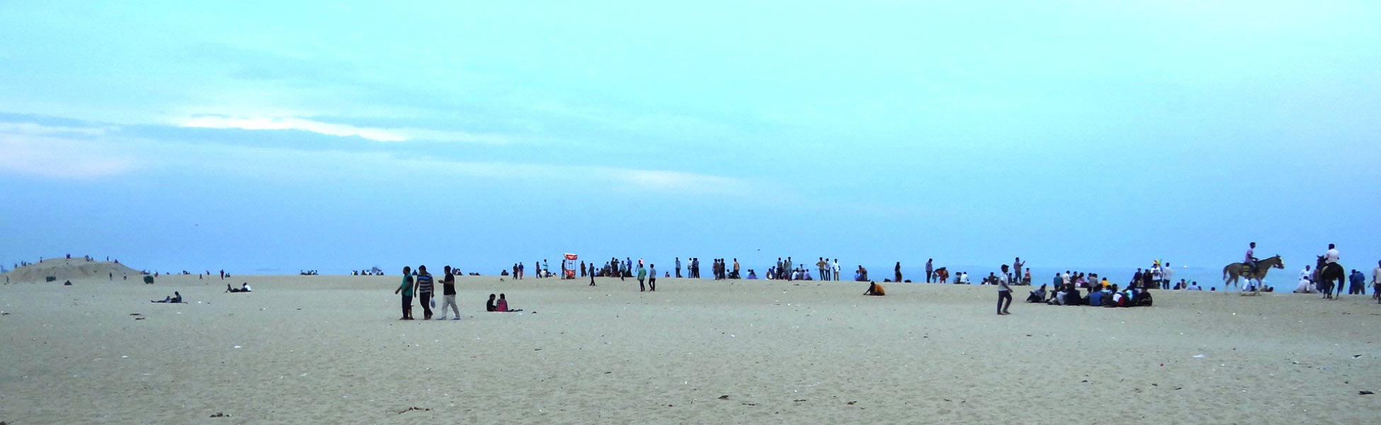 Wide-angle panoramic view of Marina Beach in Chennai during blue hour, showing film shooting location potential with wide sandy shores, local crowds, and horse riders under a vast sky. fixer in Basirhat, film fixer in Basirhat, media fixer in Basirhat, movie fixer in Basirhat, production fixer in Basirhat, line producer in Basirhat