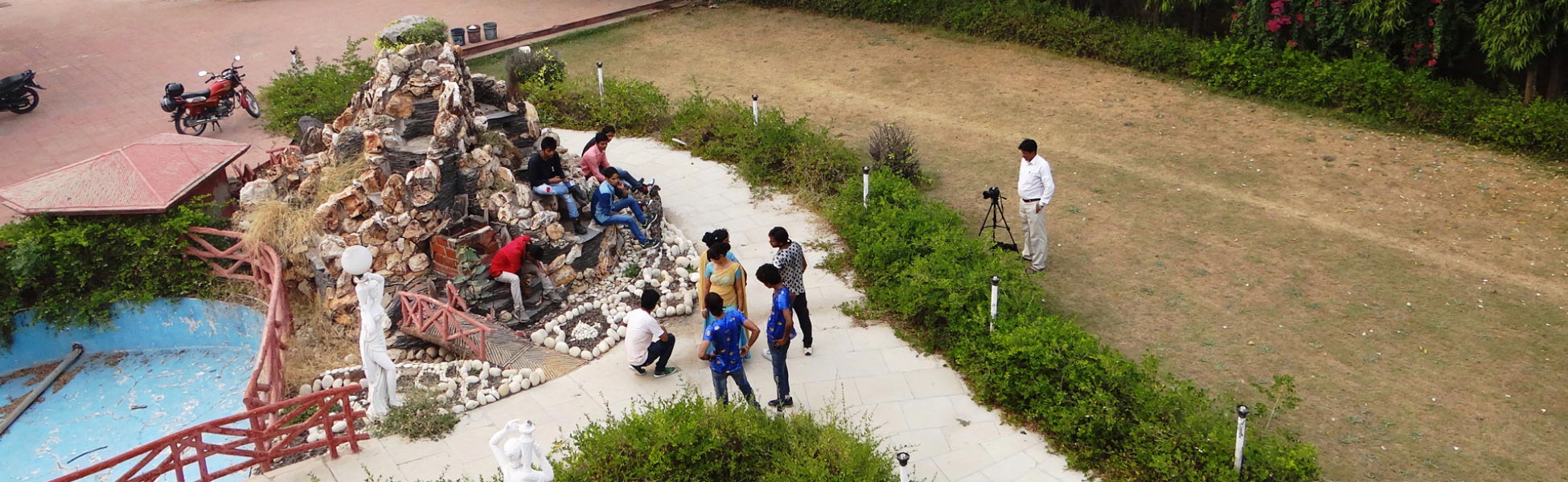 High-angle wide shot of the Trisna Films production crew, camera operator on tripod, and cast on set during an outdoor music video shoot in India. film shooting locations in Belize, video shooting locations in Belize, tv shooting locations in Belize, shooting locations in Belize