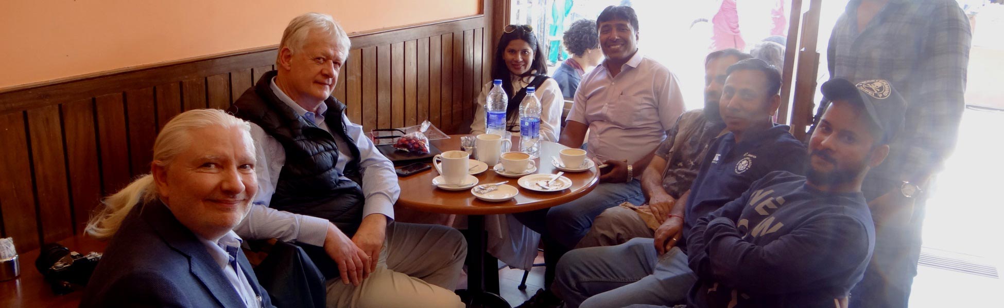 Trisna Films line production crew and international filmmakers sitting at a cafe table in McLeod Ganj Dharamshala during the shoot of Infinite Potential documentary. film production house in Bhadrak, video production house in Bhadrak, tv production house in Bhadrak, production house in Bhadrak, film production company in Bhadrak, video production company in Bhadrak, tv production company in Bhadrak, production company in Bhadrak