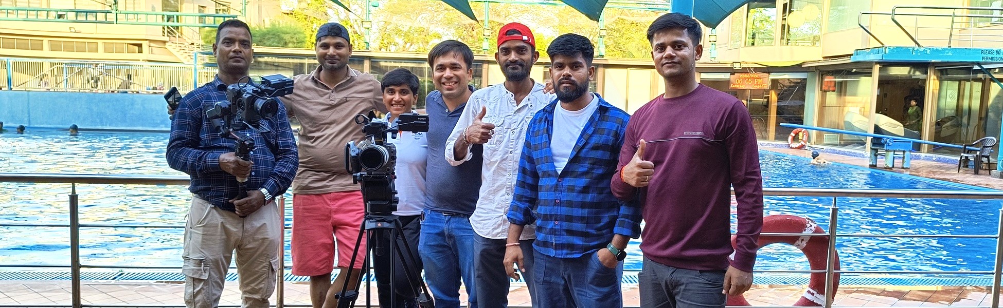 The Trisna Films® production crew standing with professional camera equipment by an outdoor swimming pool in Ahmedabad, Gujarat, during the filming of the IOC Young Leaders documentary featuring Pragnya Mohan. film shooting locations in Angul, video shooting locations in Angul, tv shooting locations in Angul, shooting locations in Angul