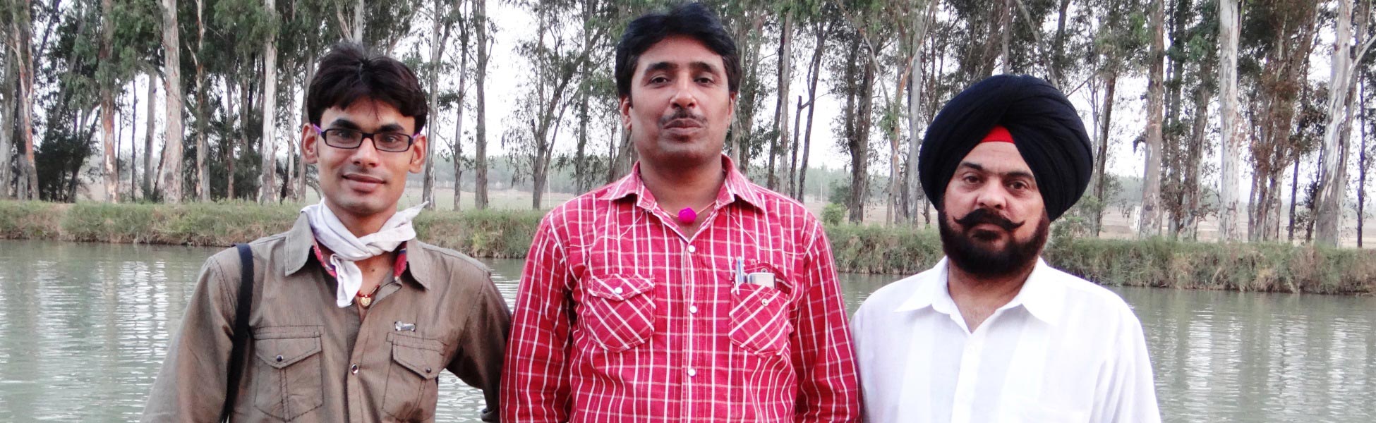 Three members of the Trisna Films® crew posing together by a water body during a corporate video production shoot in Ludhiana, Punjab, India. film shooting locations in Aravalli, video shooting locations in Aravalli, tv shooting locations in Aravalli, shooting locations in Aravalli