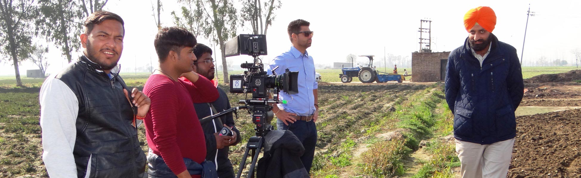 A Trisna Films® production crew standing with a professional cinema camera in an agricultural field in Ludhiana, Punjab, filming a web series for New Holland Tractors, Italy. film shooting locations in australia, video shooting locations in australia, tv shooting locations in australia, shooting locations in australia