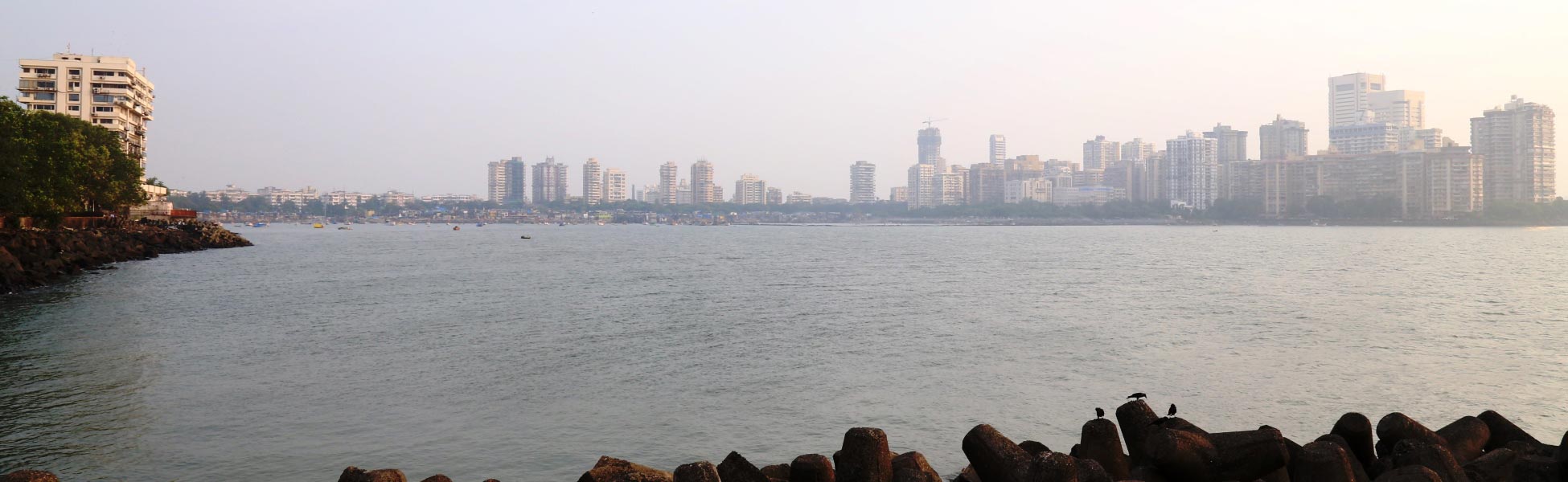 Panoramic wide-angle view of the Cuffe Parade skyline and high-rise buildings across the Arabian Sea, captured from the Nariman Point tetrapod shoreline in South Mumbai. film shooting locations in Austria, film shooting locations in vienna, video shooting locations in Austria, video shooting locations in vienna, tv shooting locations in Austria, tv shooting locations in vienna, shooting locations in Austria, shooting locations in vienna